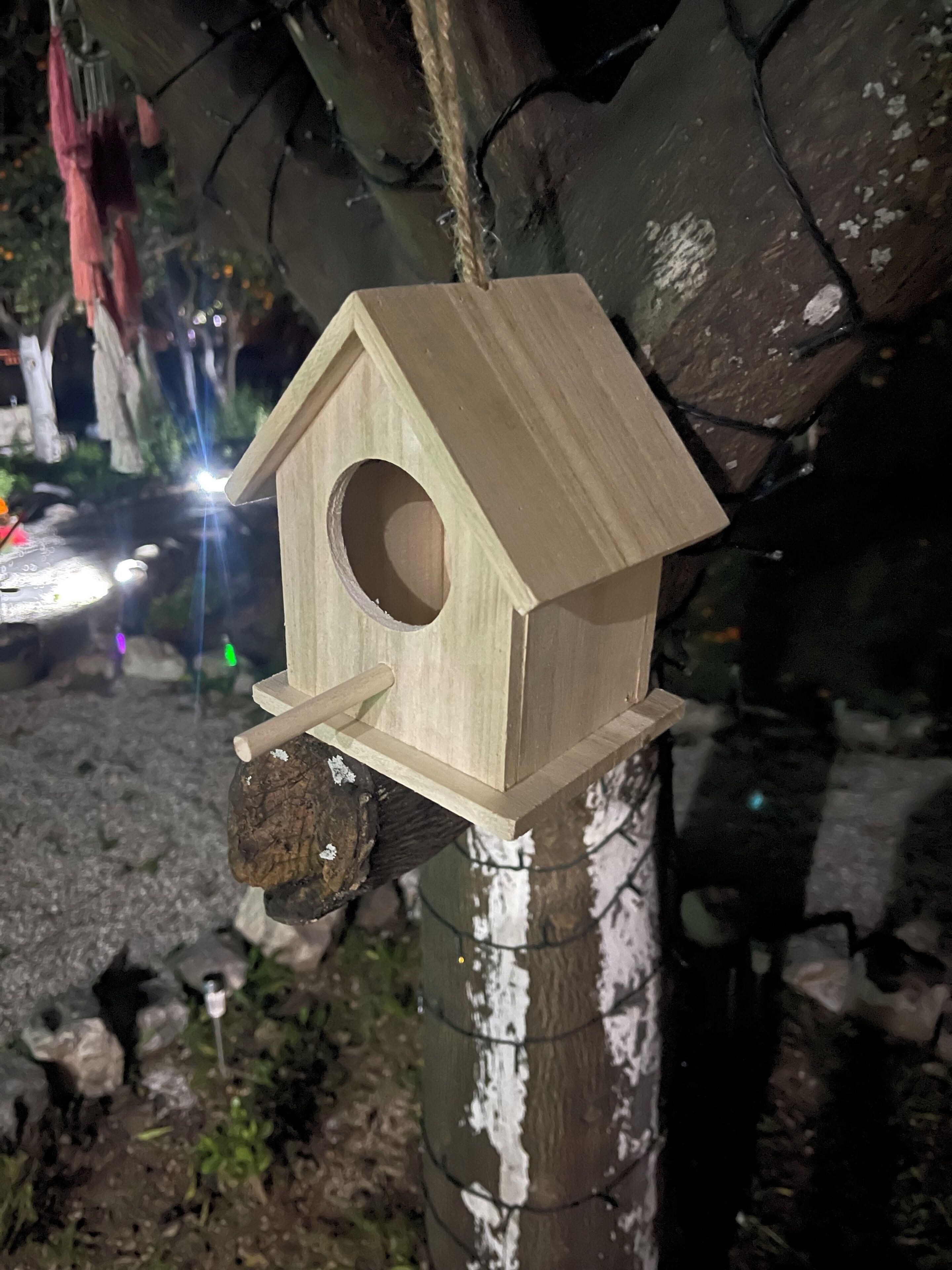 Un comedero de madera sujeto a un árbol.