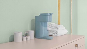 Een badkamer met een toilet, een stapel handdoeken en enkele toiletartikelen op een aanrecht.