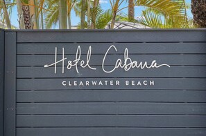 Un letrero de madera con el texto 'Hotel Cabana' y 'CLEARWATER BEACH', indicando el nombre del hotel y su ubicación.