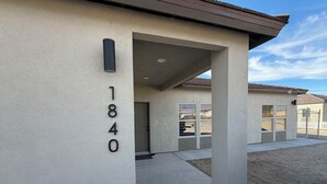 A building with a concrete facade, a number '1840' sign, and a covered entrance area.