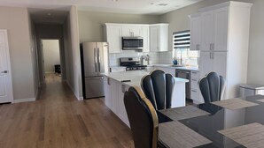 A modern kitchen with white cabinets, stainless steel appliances, and a central island with seating.