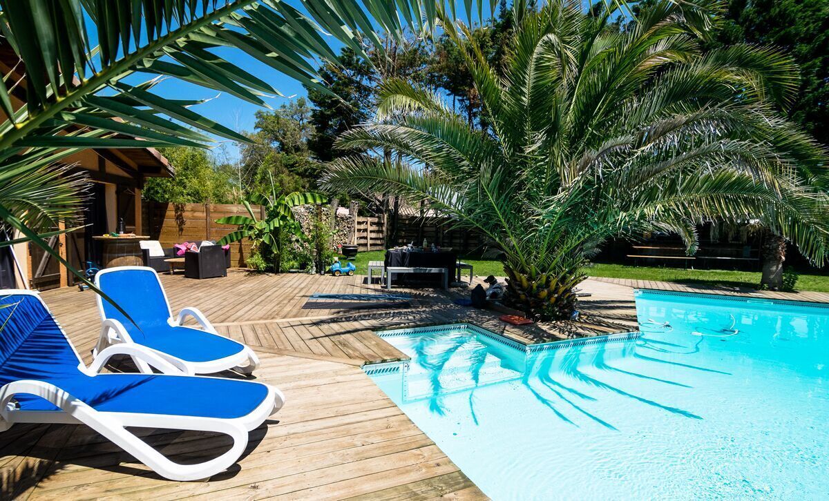 Grande piscine privée chauffée selon la saison, entourée de terrasses