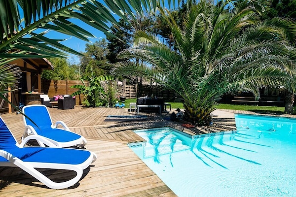 Grande piscine privée chauffée selon la saison, entourée de terrasses