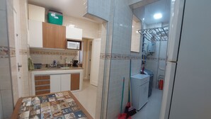 A compact kitchen with a microwave, coffee maker, and a refrigerator. - Quiet apartment, excellent location in Copacabana, 5 minutes from the beach. (Rio de Janeiro)