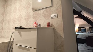 A bathroom with a mirror, a towel rack, a sink, and a toilet.