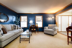 A living room with a sofa, armchair, coffee table, lamp, and piano. - The Ultimate Irish Getaway | 1.5 Miles from Campus (South Bend)