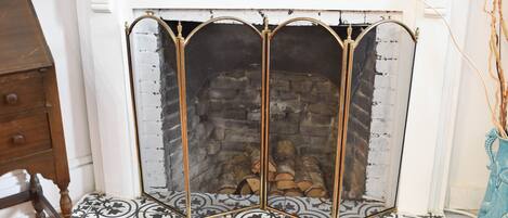 A fireplace with a decorative metal screen and a patterned floor.
