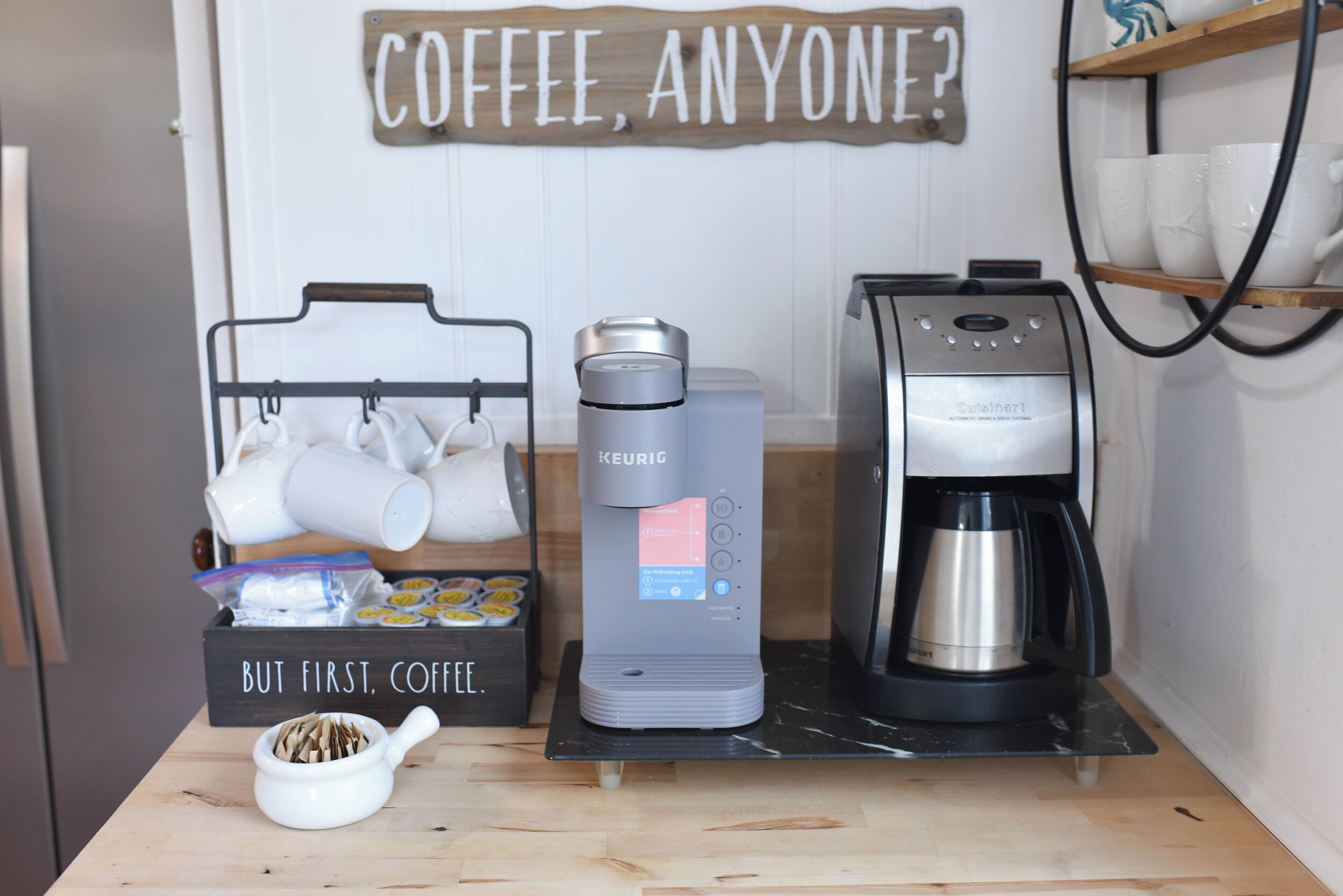 A coffee station with a Keurig machine, a coffee maker, and a mug rack.