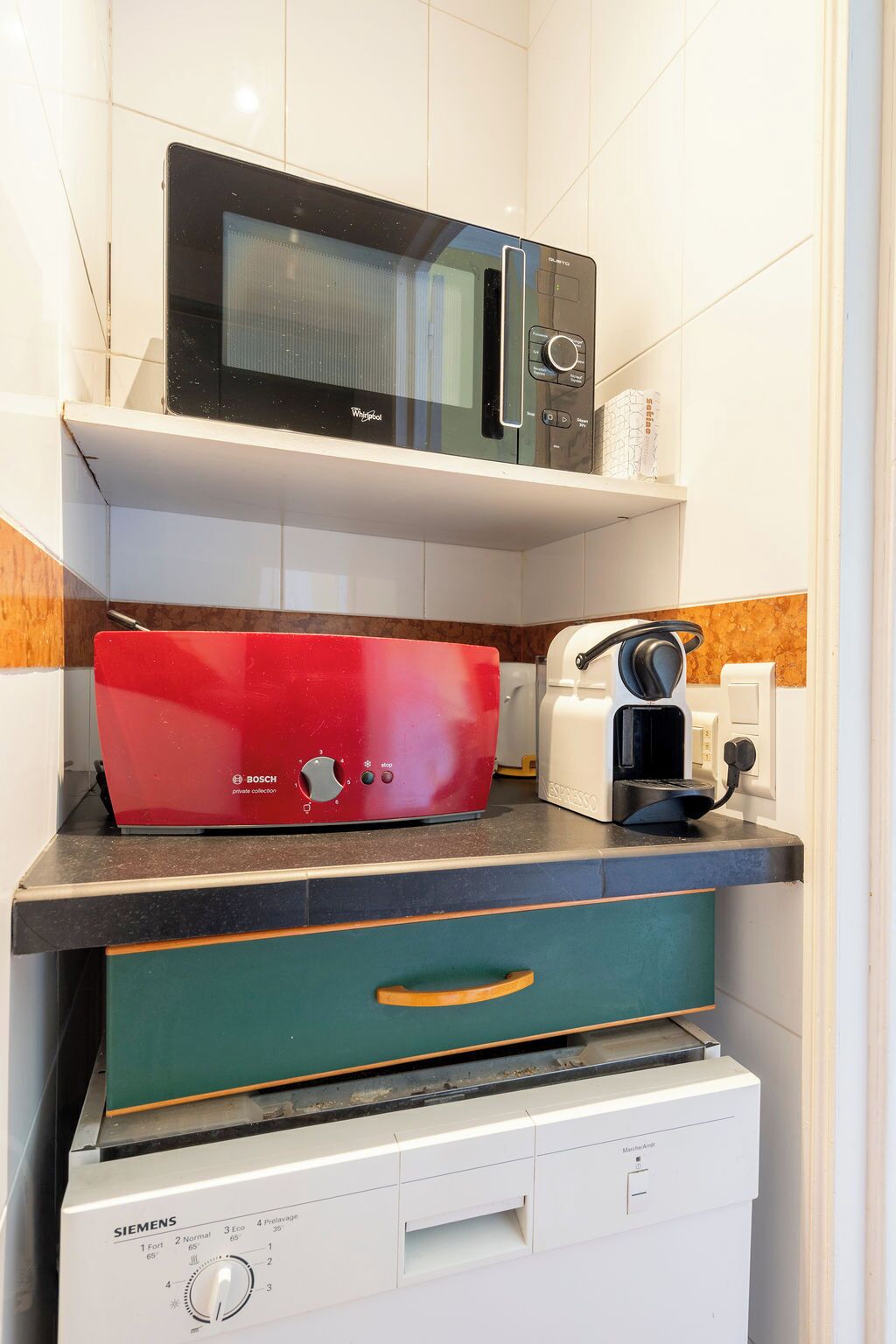 A kitchen with a microwave, toaster, and coffee maker on a countertop.