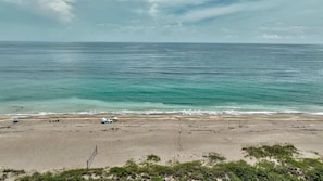 Una playa con agua turquesa cristalina, una orilla arenosa y algo de vegetación al frente.