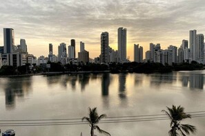 A city skyline with high-rise buildings and a calm body of water reflecting the structures. - Modern Cartagena Suite with Adjustable Bed & Washer/Dryer (Cartagena)