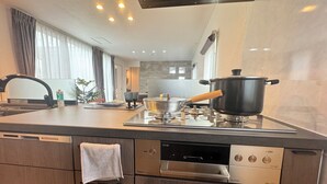 Une cuisine moderne équipée d’un lave-vaisselle encastré, d’une cuisinière et d’une casserole posée sur le plan de travail.