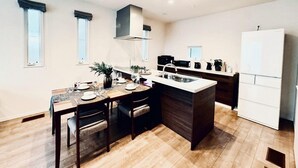 Una cocina moderna con una isla central, horno empotrado y refrigerador blanco.