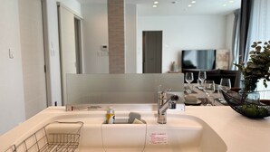 A modern bathroom with a large mirror, a sink with a soap dispenser, and a towel rack. - Akikawa Koshi 5 | 15 min to TSMC | Entire 3LDK House | Up to 4 Guests (合志市)
