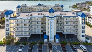 Un hôtel à plusieurs étages, doté d’une entrée principale, d’un parking et offrant une vue sur l’eau.