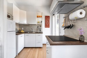 A modern kitchen with white cabinets, a wooden countertop, and a stainless steel sink. - Limone Apt · Lake View - Finestra sul Lago (Malcesine)