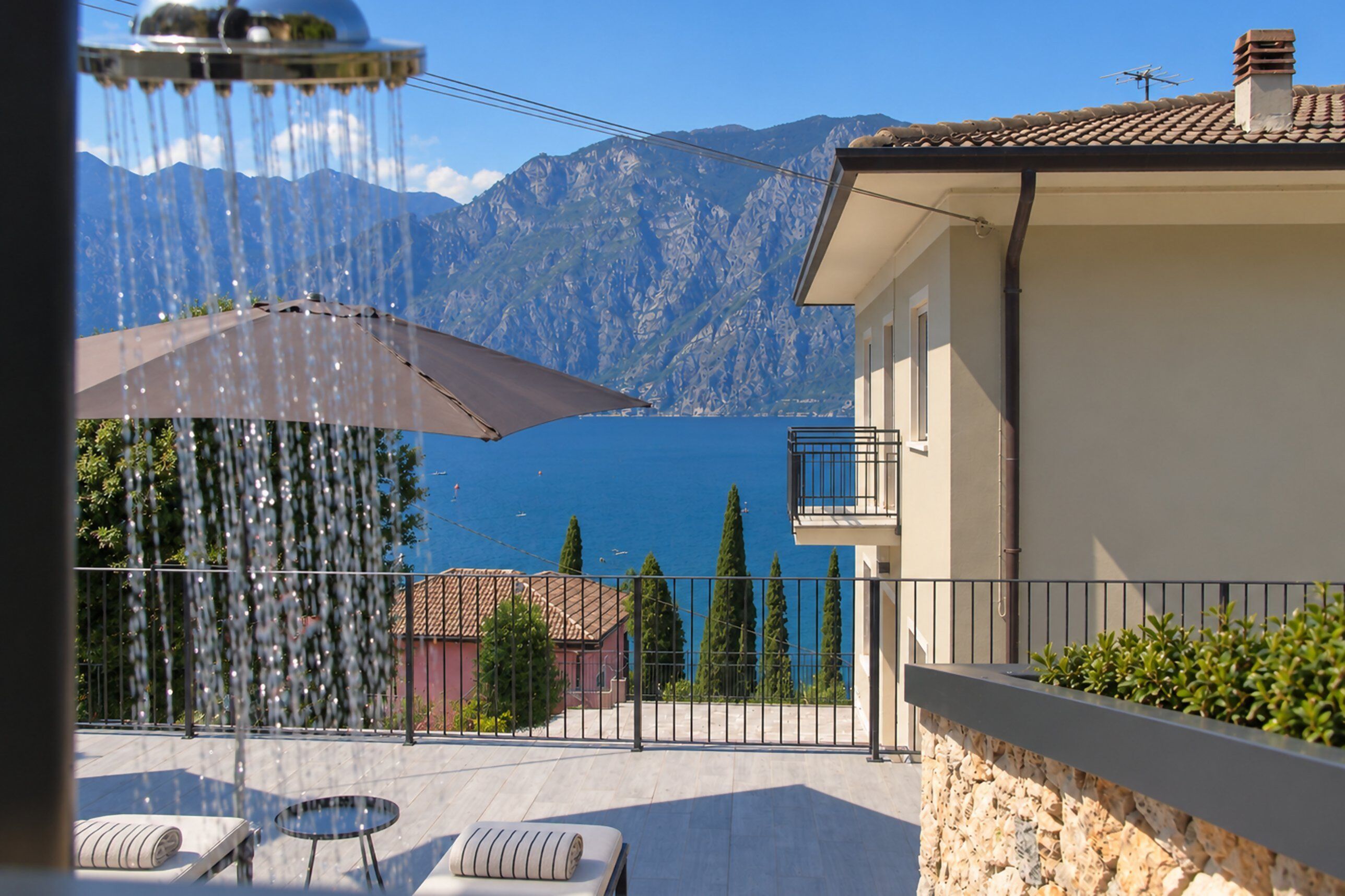 A balcony with a view of a mountain and a body of water.