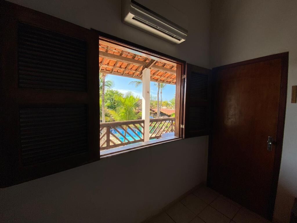 A room with a window, a door, and a ceiling vent.
