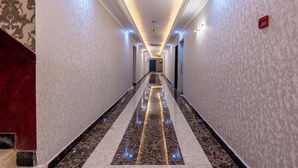 A long, well-lit hallway with patterned walls and a marble floor. - Gulf Star Hotel (Dubai)