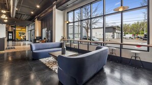A modern interior with seating, large windows, and a visible street view.