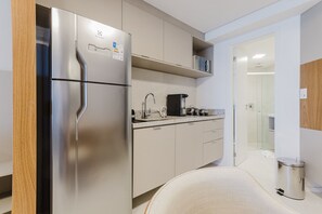 A modern kitchen with a stainless steel refrigerator, a coffee maker, and a trash can. - Vivant New Building Seafront in Recife (Recife)