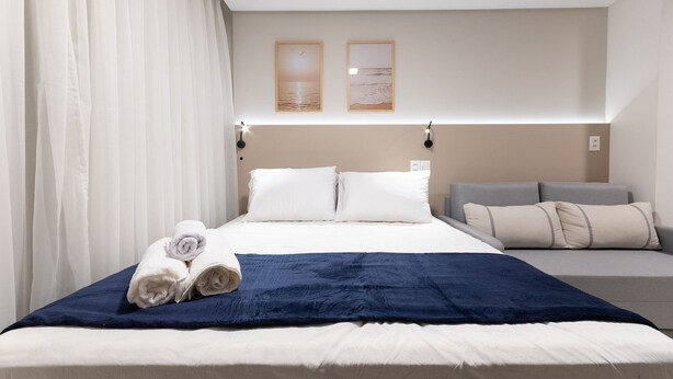 A hotel room with a bed, a sofa, and two framed pictures on the wall. - Vivant New Building Seafront in Recife (Recife)
