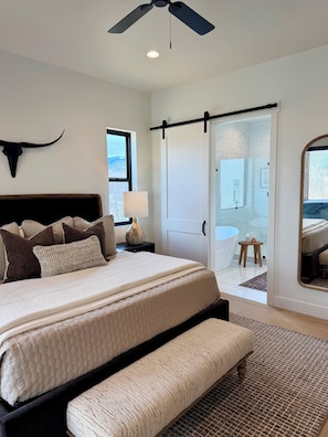 A bedroom with a bed, bedside table, lamp, and a large mirror. - Ski Hill Haven in beautiful Driggs, Idaho.  Sleeps up to 15 guests. (Driggs)