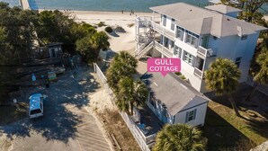 A coastal property with a beach view, a multi-story building, and a fenced parking area. - Gull Cottage (Tybee Island)