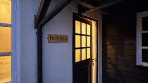 A house with a sign reading 'Hollyhock' and a black door. - Dickleburgh Crown (Diss)