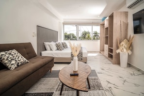 Una sala de estar moderna con un sofá, una mesa de centro y un televisor.