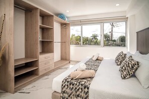 Un dormitorio con una cama grande, un armario de madera, una ventana con vistas y una zona de baño.
