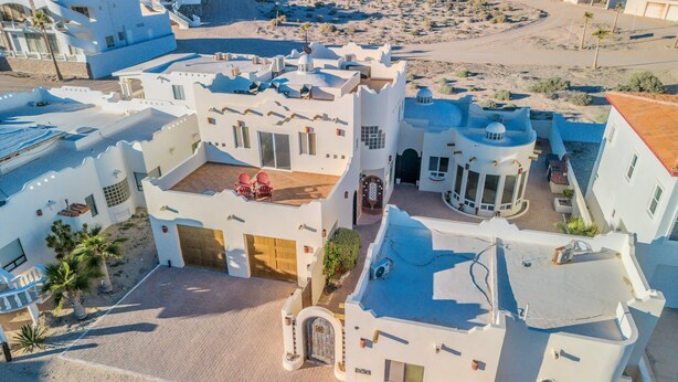 Un bâtiment blanc doté d’une cour, d’un patio couvert et d’un espace piscine.