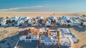 Une station balnéaire avec des bâtiments blancs, une plage et l’océan.
