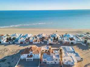 Ein Küstenort mit weißen Gebäuden, einem Strand und dem Meer.