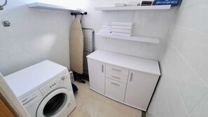 A compact laundry room with a Bosch washing machine, a white cabinet, and a towel rack. - Beachside apartment Belle Vue 1 (Okrug Donji)