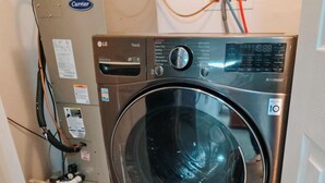 A front-loading LG ThinQ washer with a digital display, control panel, and a 10-minute timer. - Helix / King Bed / Elevator  Adjustable Desk (Philadelphia)
