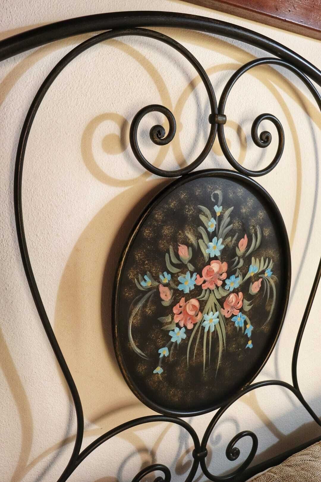 Estructura metálica con un diseño floral pintado.