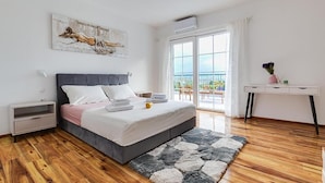 A modern bedroom with a bed, bedside tables, a desk, and a balcony view. - Beautiful home in Benkovac (Benkovac)
