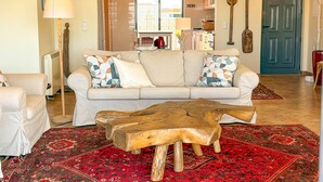A living room with a sofa, a coffee table, and a patterned rug.