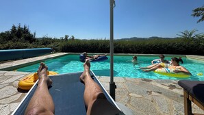 En swimmingpool med liggestole og parasoller.