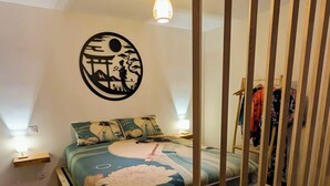 A bedroom with a wooden bed, a wall-mounted circular artwork, and a hanging light fixture. - Zen Sakura - The Breath of Asia! (Belfort)