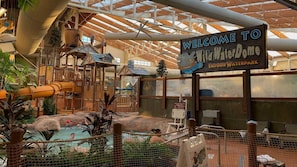 An indoor water park with a sign reading "Welcome to Wild WaterDome Indoor Waterpark." - Great Smokies Lodge 2BR Deluxe – Water Park & Outdoor Adventure (Sevierville)