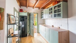 A kitchen with wooden cabinets, a black refrigerator, and a wooden countertop. - Casa Olivo Vélez-Málaga by Ruralidays (Málaga)