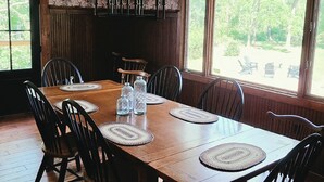 A dining area with a wooden table, six chairs, and a chandelier.