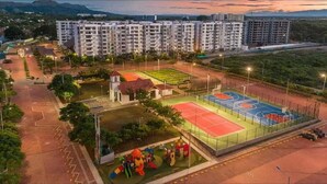 Ein Wohnkomplex mit mehreren Mehrfamilienhäusern, einem Spielplatz und einem Sportplatz.