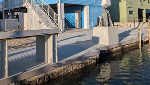 A waterfront property with a blue building, a covered walkway, and a green structure. - The Friendly Pelican
2-BDR 2-BATH on a canal w/AC in Big Pine Key (Big Pine Key)