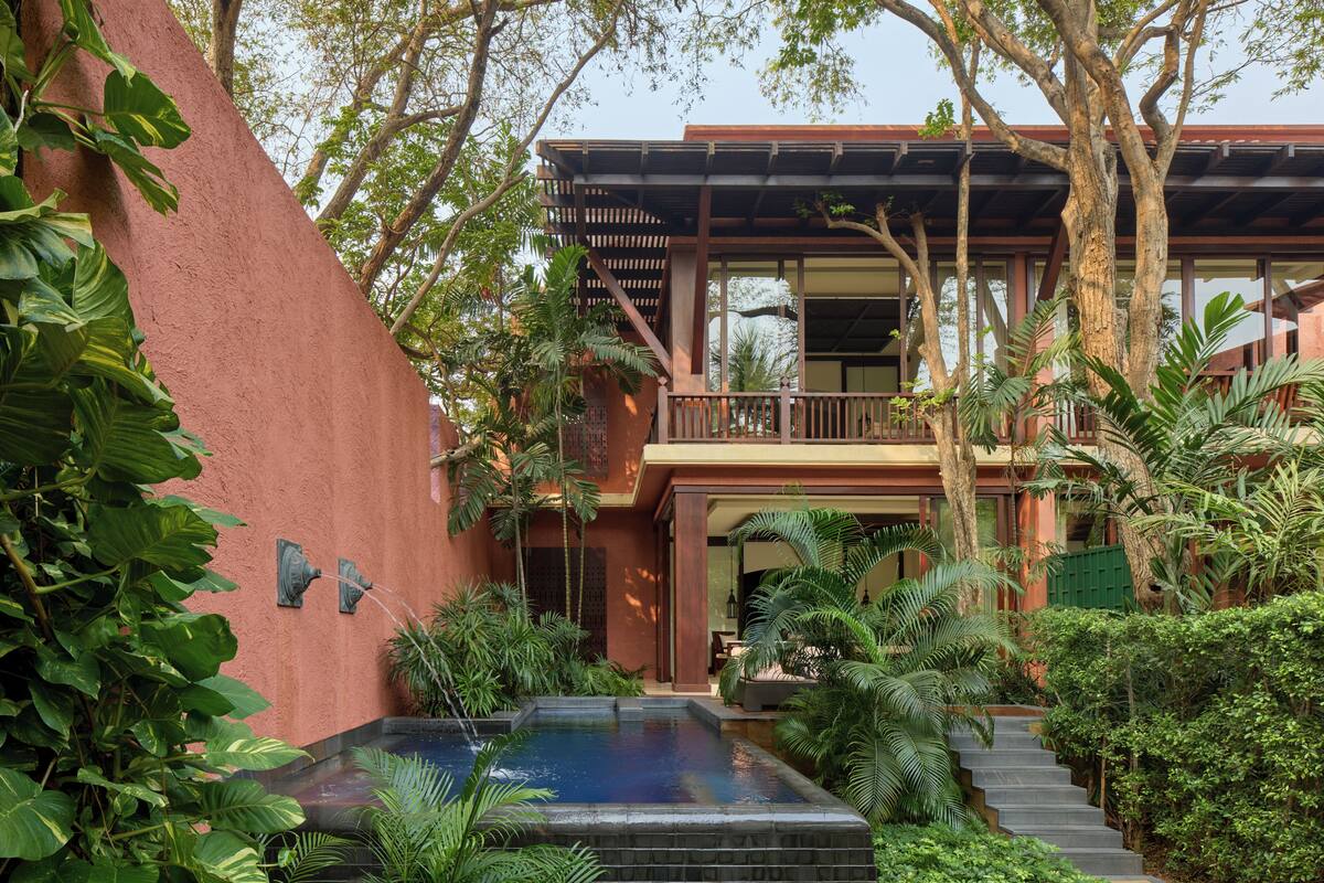 Ein Gebäude mit Pool, umgeben von üppiger Vegetation und Bäumen.