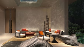 Ein modernes Interieur mit einer Sitzecke, einer hohen Dekoration und einem Oberlicht.