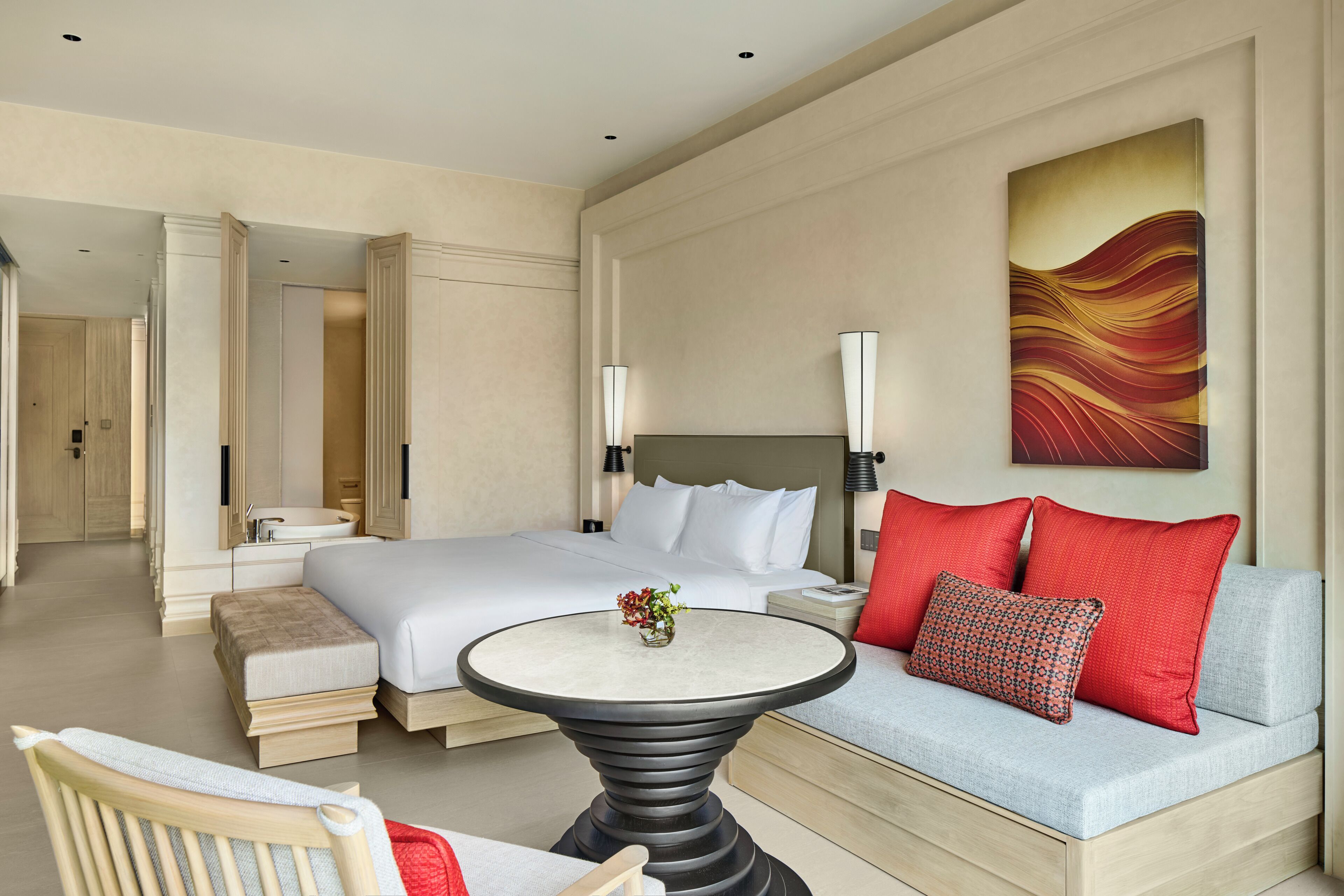 Une chambre d’hôtel avec un lit, un canapé, une table ronde et un tableau au mur.