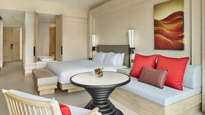 Een hotelkamer met een bed, een slaapbank, een ronde tafel en een schilderij aan de muur.